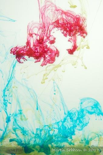 Acrylic painst dripped into a clear tank of water